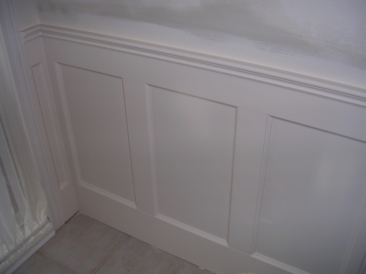 Recessed panelled wainscoting against a white wall