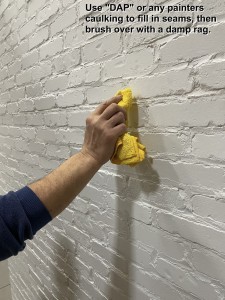 A look at how to use DAP or painter's caulking to fill in any gaps on the brick wall panels.