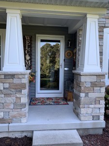 Front view of two white raised panel tapered columns on stone pedestals