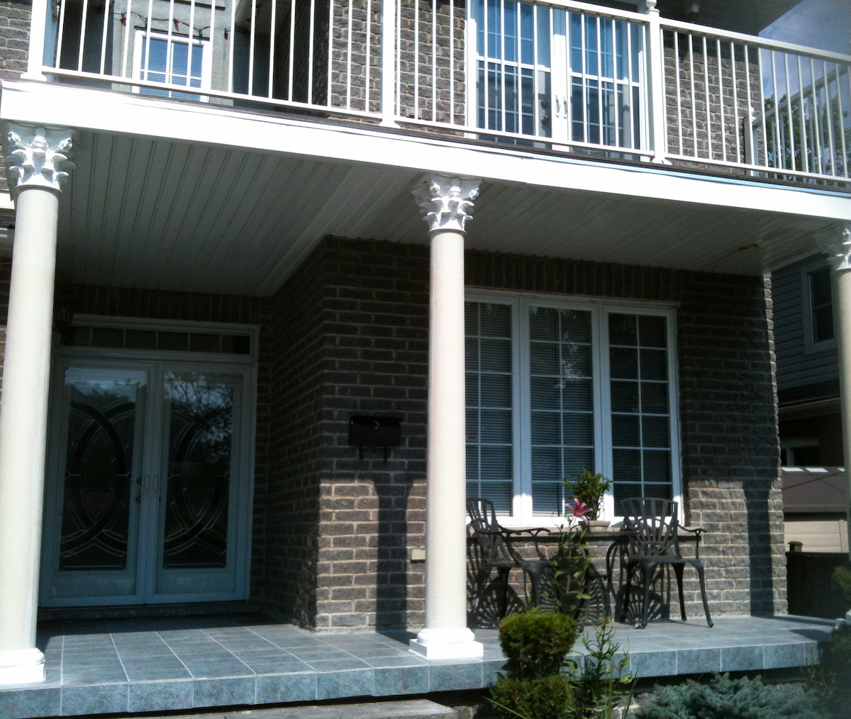 Round fibreglass columns with corinthian capitals on front porch of home